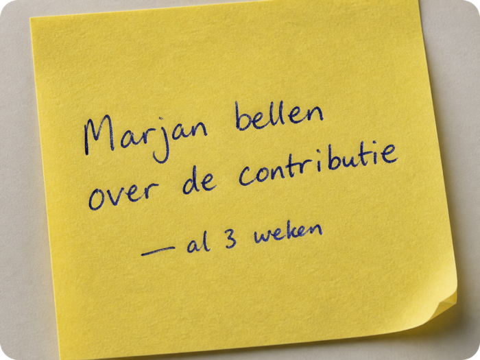 Een geel briefje met de handgeschreven notitie Marjan bellen over de contributie